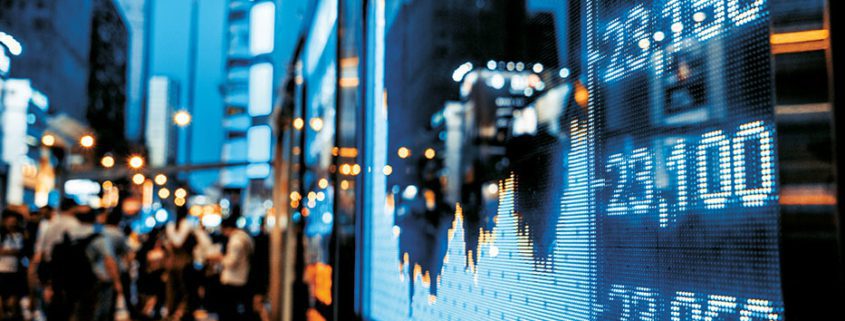 A bustling city street with people, reflected in a screen displaying stock market data and numbers, amid high-rise buildings.