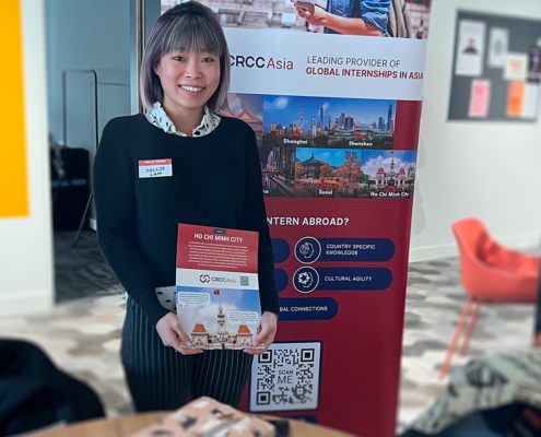 Person holding a flyer next to a CRCC Asia banner, promoting internships in Ho Chi Minh City, with images of Asian cityscapes.