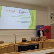 A person stands at a lecture podium, presenting a slide on the role of the United Nations. McGill University logo is visible.