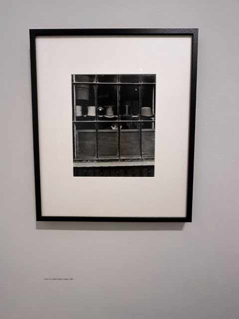 A white rectangular painting hangs in an indoor art frame.