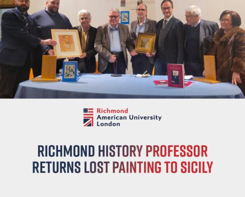 A group of people stand behind a table displaying framed artworks and a book; the image includes text about a history professor returning a painting to Sicily.
