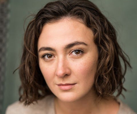 A close up image of a person with dark brown hair and brown eyes