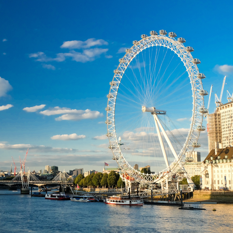 The image features the London Eye near the Thames River, with surrounding buildings, boats on the water, and a bright blue sky.