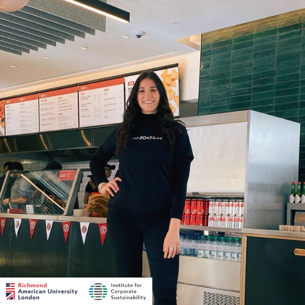 A person stands in a restaurant interior, posing near a counter with drinks. Menus are visible in the background.