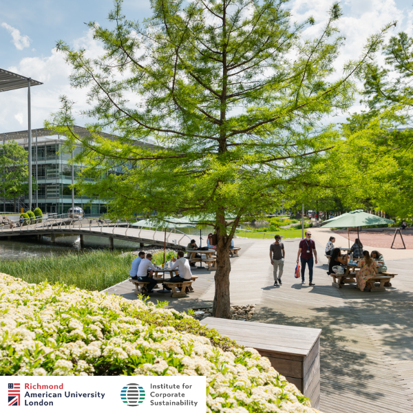 A scenic park setting with people sitting and walking near a pond, surrounded by trees, flowers, and a modern glass building in the background.