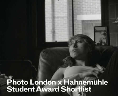 A person lounges on a chair indoors, gazing upward. Brick building visible through window. Text: "Photo London x Hahnemühle Student Award Shortlist."