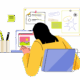 A person working on a laptop at a desk with a pencil holder, notes, and colorful images on a whiteboard.