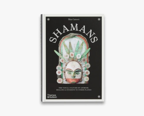 The image shows the book cover for "Shamans" by Max Carocci, featuring an intricate mask design against a black background.